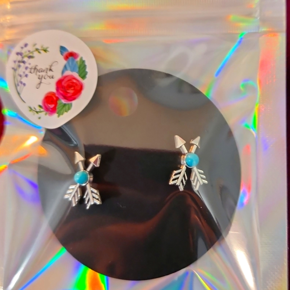 Crossed Arrow studs with turquoise center.